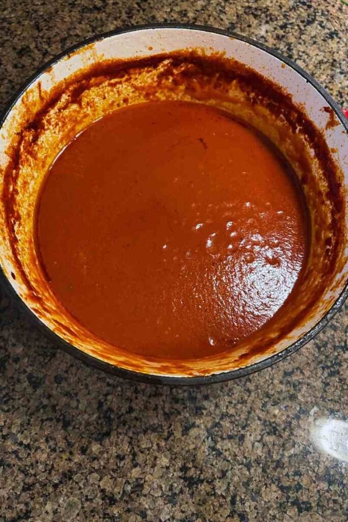Close-up of a pot of freshly made classic Italian tomato sauce with pork and herbs.