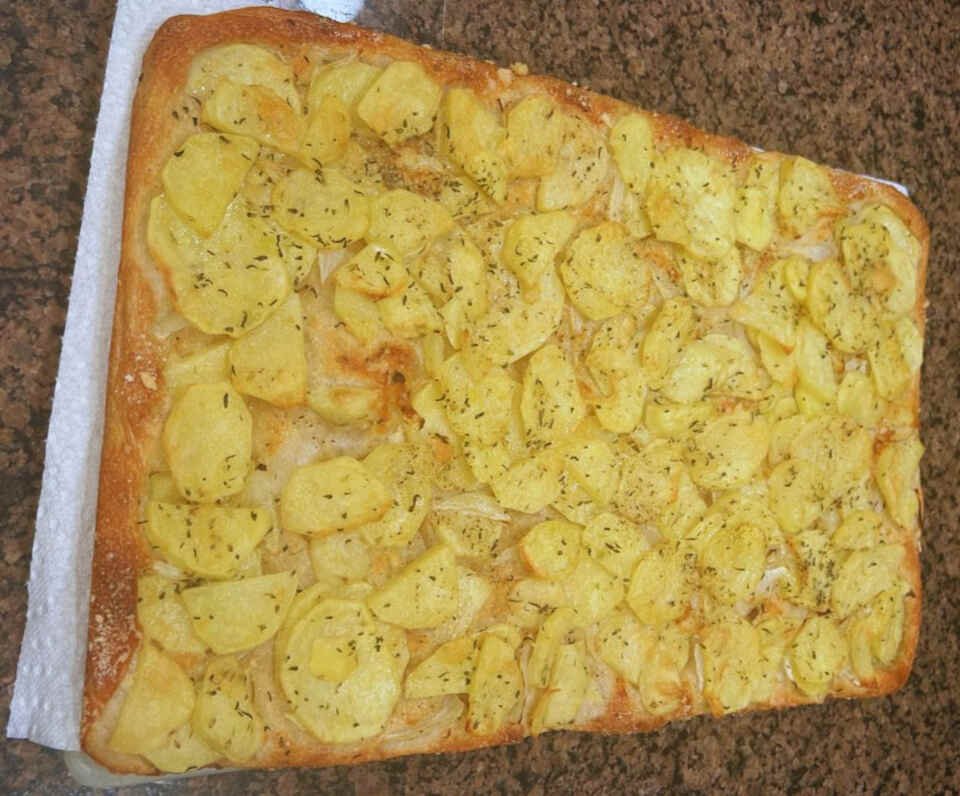A potato pizza just removed from the oven.