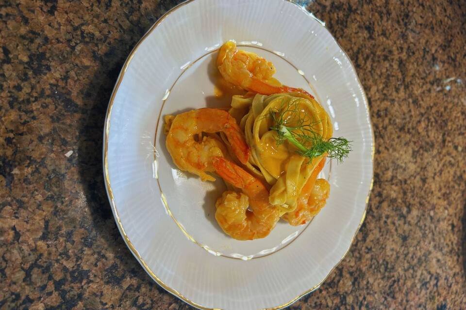A close-up photo of a freshly made plate of rose shrimp pasta.