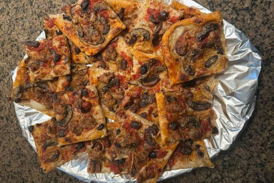 Platter of homemade pizza with sausage.