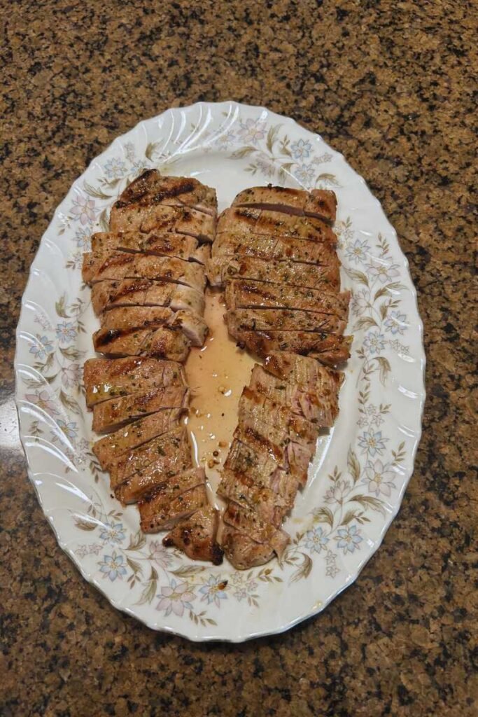BBQ Grilled Pork Loin with Herb Marinade on a platter on the kitchen countertop.